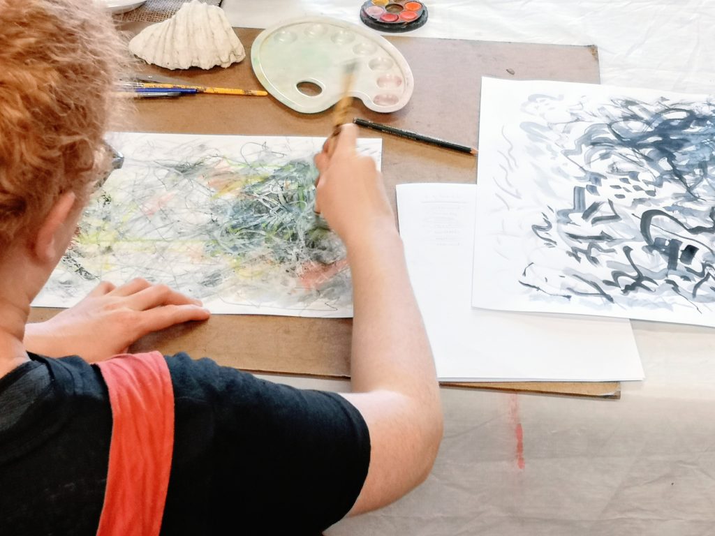 Hands working on an artwork during an individual art therapy session
