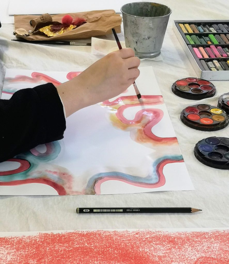 Watercolour brushwork on paper with a palette of paints